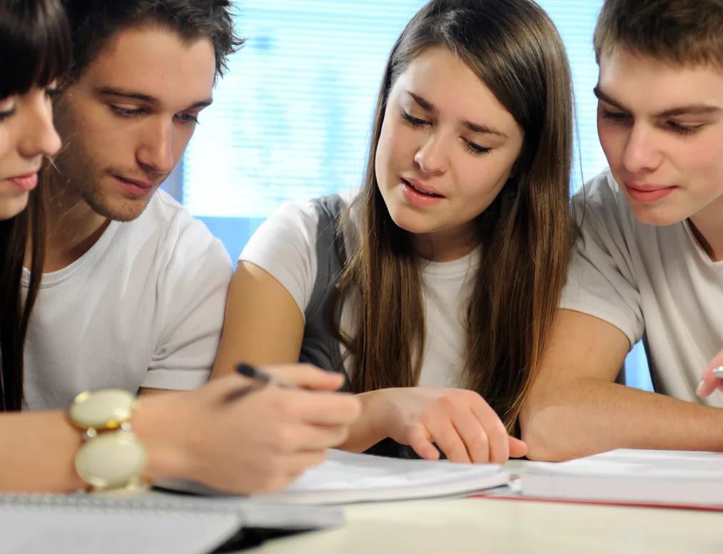 Group of students engaged in an interactive English class, collaborating on assignments and improving their language skills together.